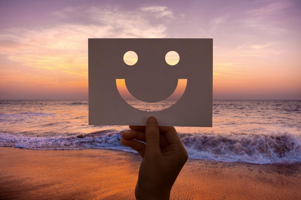 ilustrasi kertas dibentuk emoji senyum dengan pemandangan pantai (Freepik)