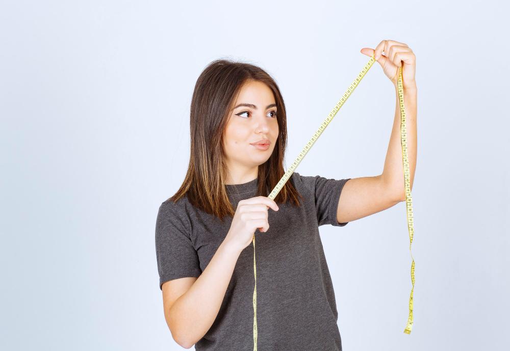 ilustrasi: wanita muda sedang melihat tali pengukur tinggi badan (Freepik)