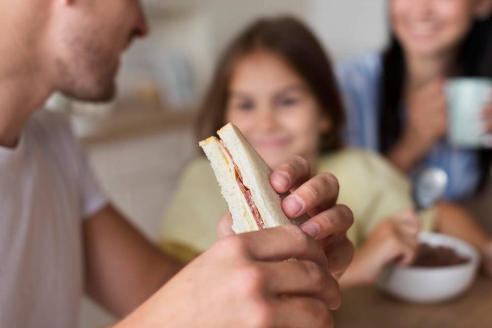ilustrasi seorang ayah memegang roti sandwich dengan latar belakang anak dan istri (freepik)