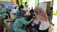 Nakes saat melakukan imunisasi kepada siswa SD (suara jatim)