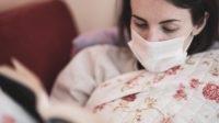 ilustrasi perempuan menggunakan masker karena flu (unsplash)