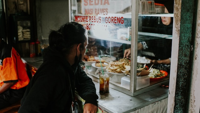 ilustrasi pria sedang makan di warung pinggiran (unsplash)