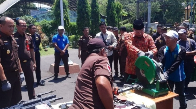 Bupati Sidoarjo memotong senjata api rakitan dengan gerinda dalam acara pemusnahan barang bukti di halaman Kejari Sidoarjo, Selasa 26 September 2023. (SuaraJatim)