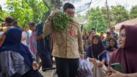 Bupati Kediri Hanindhito Himawan Pramono saat memikul sayuran dari para petani (Humas Pemkab Kediri)