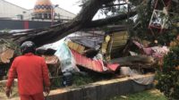 Foto : Petugas Mengevakuasi Pohon Tumbang Yang Menimpa Lapak Pedagang dan Pengunjung di Alun alun Koya Blitar (Bahtiar/Metara)