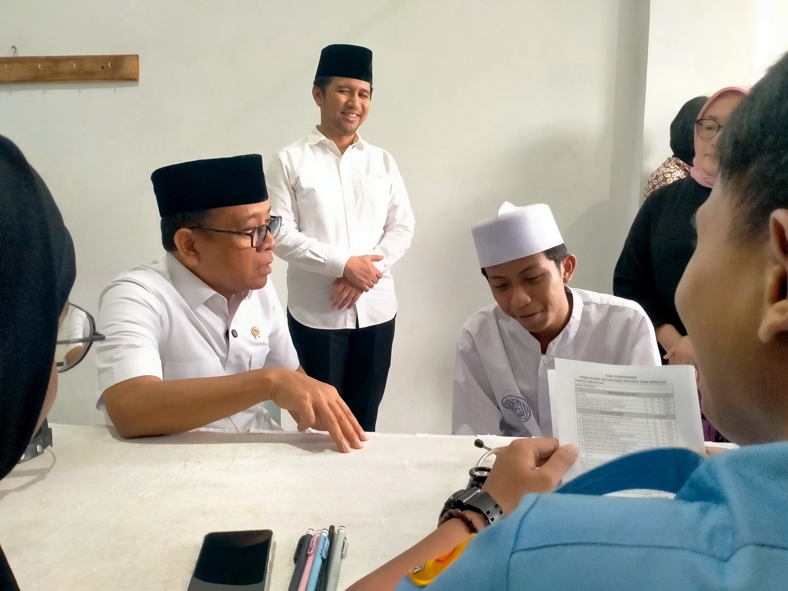 Caption : Menko Pembangunan Manusia dan Kebudayaan (PKM) RI, Prof. Dr. Pratikno, didampingi oleh Wakil Gubernur Jatim, Emil Elestianto Dardak, saat melihat santri Al-Falah Ploso, melaksanakan pemeriksaan kesehatan gratis, Minggu (13/7/2025). Dok : M Nasrul.