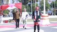 Bupati Jember mengenakan syal bermotif bendera Palestina berjalan menuju mimbar dalam upacara HUT ke-80 RI di Alun-alun Jember, Minggu (17/8/2025). (Foto: Dok/Diskominfo Jember)