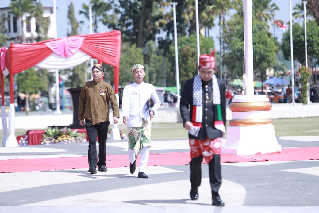 Bupati Jember mengenakan syal bermotif bendera Palestina berjalan menuju mimbar dalam upacara HUT ke-80 RI di Alun-alun Jember, Minggu (17/8/2025). (Foto: Dok/Diskominfo Jember)